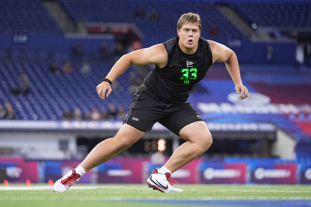 FILE - Utah offensive lineman Caleb Lomu (33) runs a drill at the NFL football scouting combine in Indianapolis, March 1, 2026. (AP Photo/Michael Conroy, File)