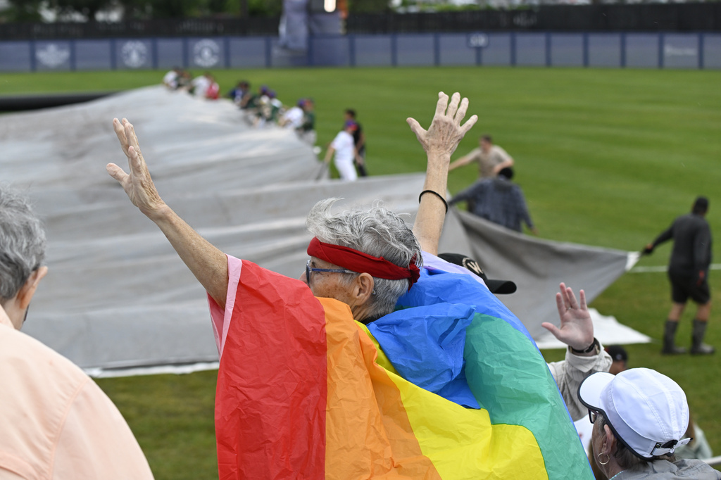 A fan reacts while the tarps are removed from the field before the inaugural Women's Professional Baseball League game between the Los Angeles Queens and the New York Heights, Saturday, Aug. 1, 2026, in Springfield, Ill. (AP Photo/Lexie Knight)