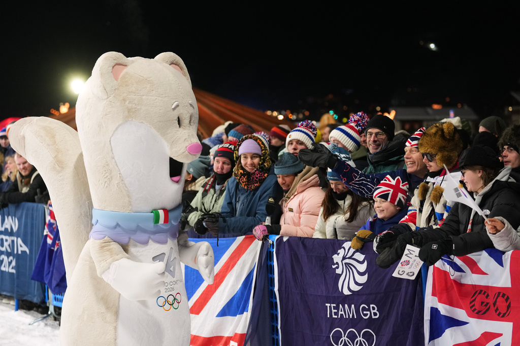 Olympic mascot Tina interacts with fans before the women's snowboarding big air finals at the 2026 Winter Olympics, in Livigno, Italy, Monday, Feb. 9, 2026. (AP Photo/Lindsey Wasson)