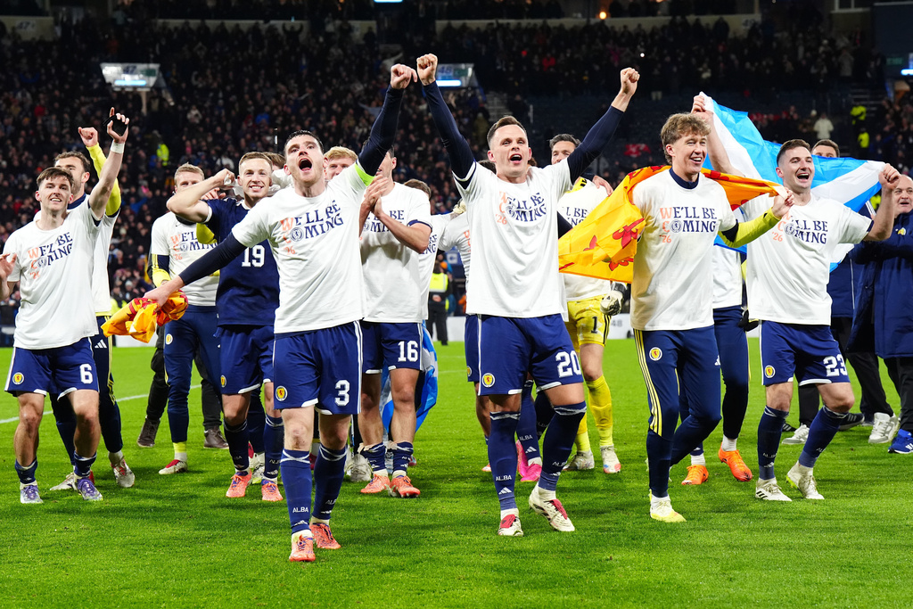 Scotland's Andrew Robertson, front left ,and Lawrence Shankland front right, and teammates celebrate qualifying after defeating Denmark in a 2026 World Cup European Qualifying soccer match in Glasgow, Scotland, Tuesday, Nov. 18, 2025. (Jane Barlow/PA via AP)