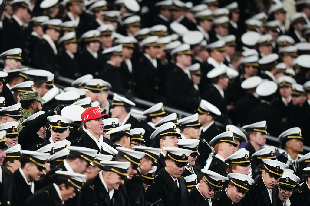 A Navy midshipman wears a red hat among others wearing white caps during the second half of an NCAA college football game against Army, Saturday, Dec. 13, 2025, in Baltimore. (AP Photo/Stephanie Scarbrough)