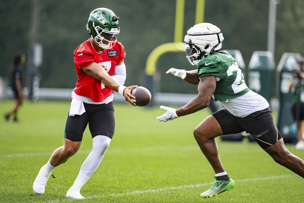 New York Jets quarterback Justin Fields (7) and running back Breece Hall (20) run drills together during practice at the team's NFL football training camp, Saturday, July 26, 2025, in Florham Park, N.J. (AP Photo/Angelina Katsanis)