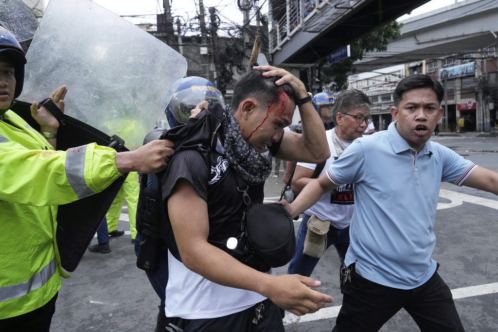 An anti-corruption protester is arrested by police during clashes as they tried to enter the Malacanang presidential palace compound in Manila, Philippines on Sunday, Sept. 21, 2025. (AP Photo/Aaron Favila)