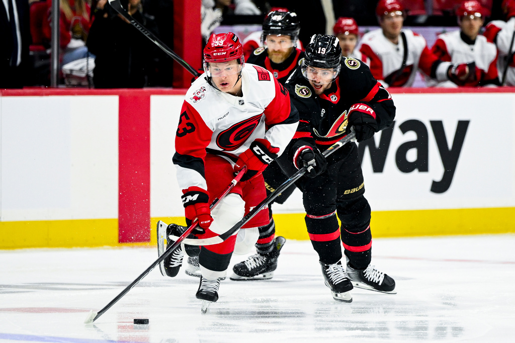 Ottawa Senators' Drake Batherson (19) defends against Carolina Hurricanes' Jackson Blake (53) as he carries the puck during first period of an NHL hockey game in Ottawa, Ontario, on Sunday, April 5, 2026. (Spencer Colby/The Canadian Press via AP)