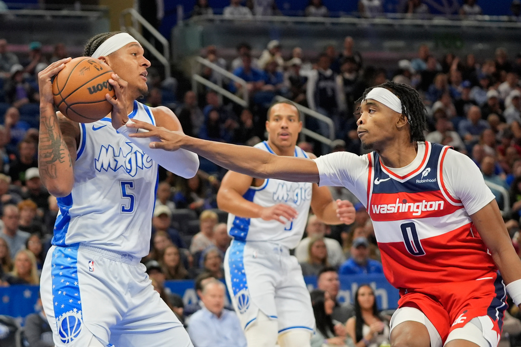 Orlando Magic forward Paolo Banchero (5) grabs a rebound in front of Washington Wizards guard Bilal Coulibaly (0) during the first half of an NBA basketball game, Thursday, March 12, 2026, in Orlando, Fla. (AP Photo/John Raoux)