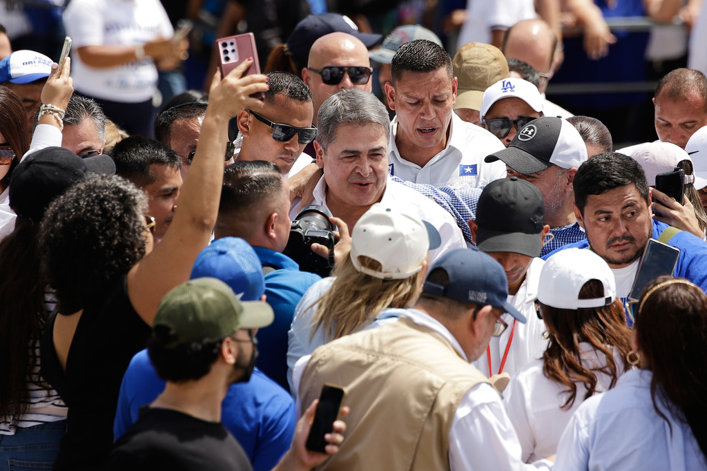 Former Honduran President Juan Orlando Hernández is surrounded by supporters after his arrival to Toncontin airport in Tegucigalpa, Honduras, Sunday, July 26, 2026. (AP Photo/Fernando Destephen)