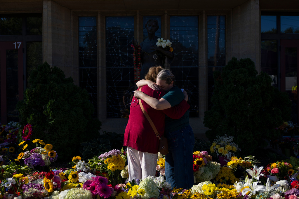 FILE - Women embrace at the memorial outside the Annunciation Catholic Church following a shooting at the school, Aug. 31, 2025, in Minneapolis. (AP Photo/Ellen Schmidt, File)