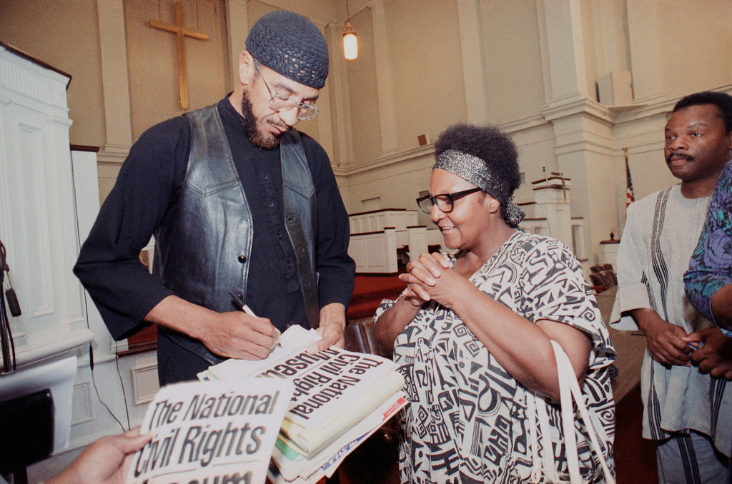 FILE - Jamil Al-Amin, formerly known as H. Rap Brown, signs a program after speaking on Monday, July 1, 1991 in Memphis. (AP Photo/Mark Humphrey, File)