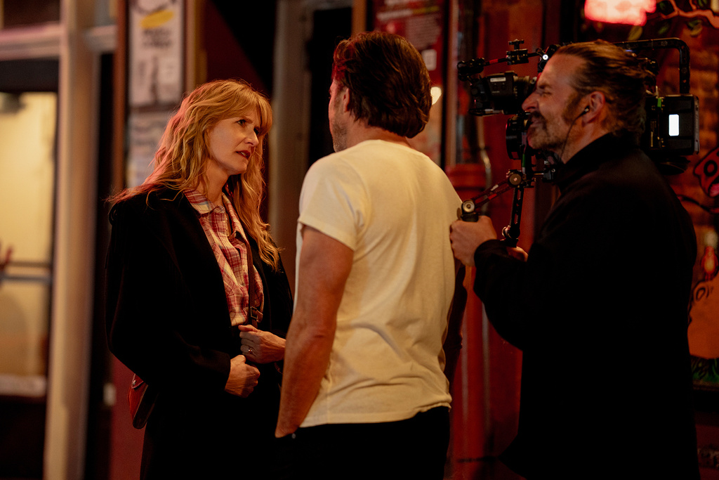 This image released by Searchlight Pictures shows Laura Dern, left, and Will Arnett with director Bradley Cooper, right, on the set"Is This Thing On?" (Jason McDonald/Searchlight Pictures via AP)