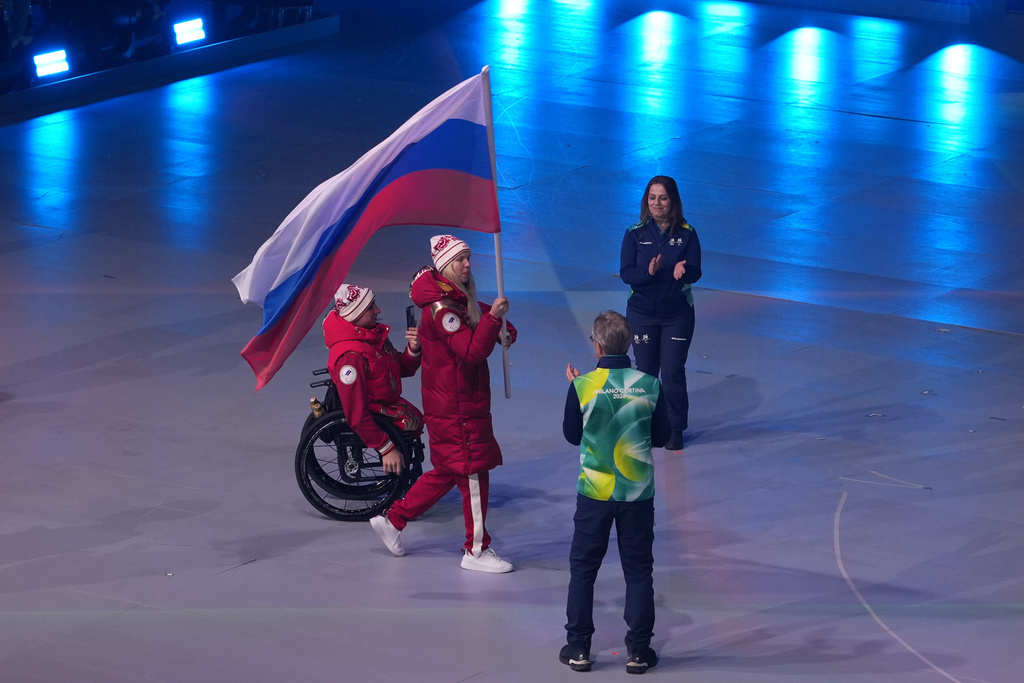 Athletes march carrying the Russian flag during the closing ceremony at the 2026 Winter Paralympics, in Cortina d'Ampezzo, Italy, Sunday, March 15, 2026. (AP Photo/Evgeniy Maloletka)
