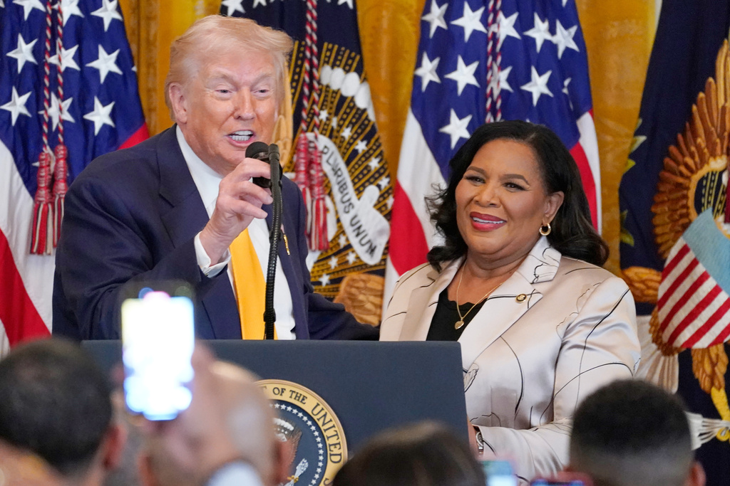 President Donald Trump speaks as White House pardon czar Alice Johnson listens during a Black History Month event in the East Room of the White House, Wednesday, Feb. 18, 2026, in Washington. (AP Photo/Nathan Howard)