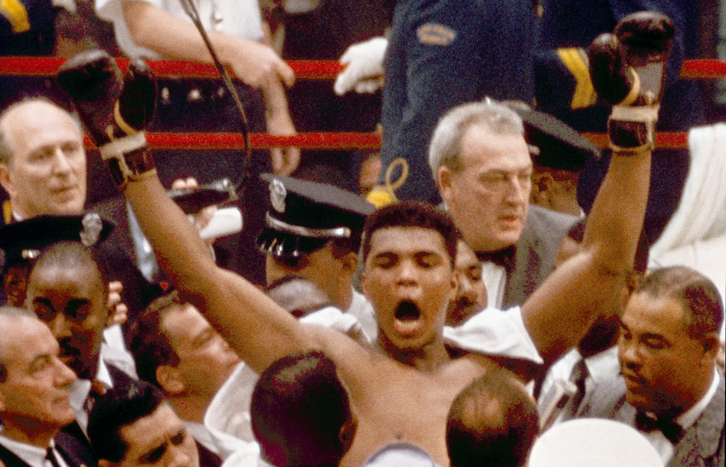 FILE - In this Feb. 25, 1964, file photo, Muhammad Ali, or Cassius Clay at the time, strikes a familiar pose as he shouts "I am the greatest," as he leaves the ring, arms raised, following his defeat of former heavyweight boxing champion Sonny Liston, in Miami Beach, Fla. (AP Photo/File)