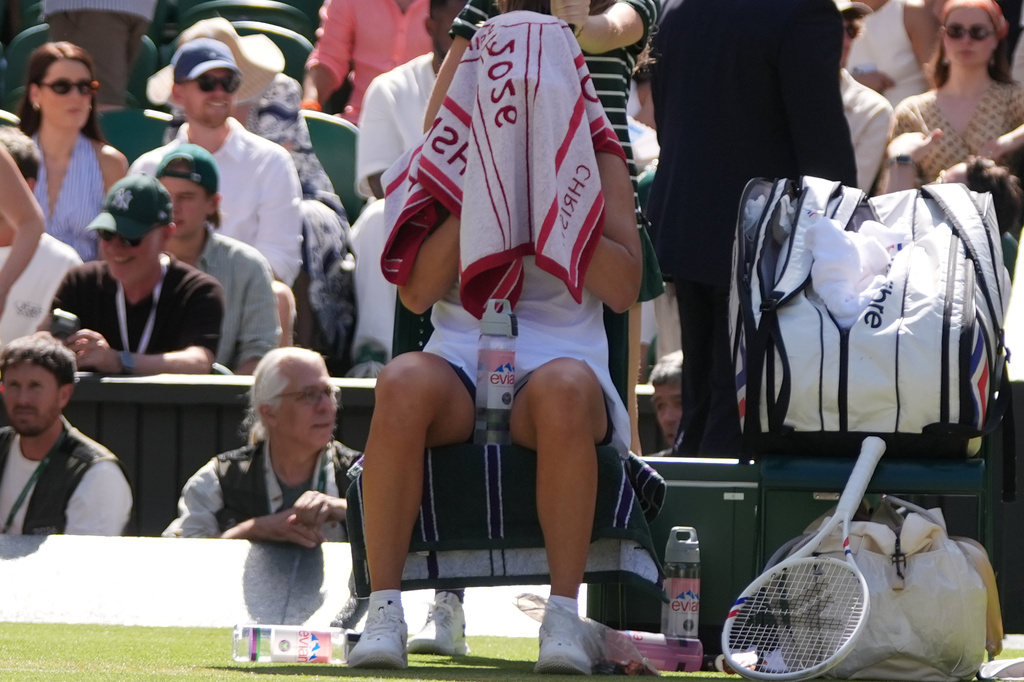 Iga Swiatek of Poland rests under her towel during the third round women's singles match against Alexandra Eala of the Philippines at the Wimbledon Tennis Championships in London, Saturday, July 4, 2026.(AP Photo/Maja Smiejkowska)
