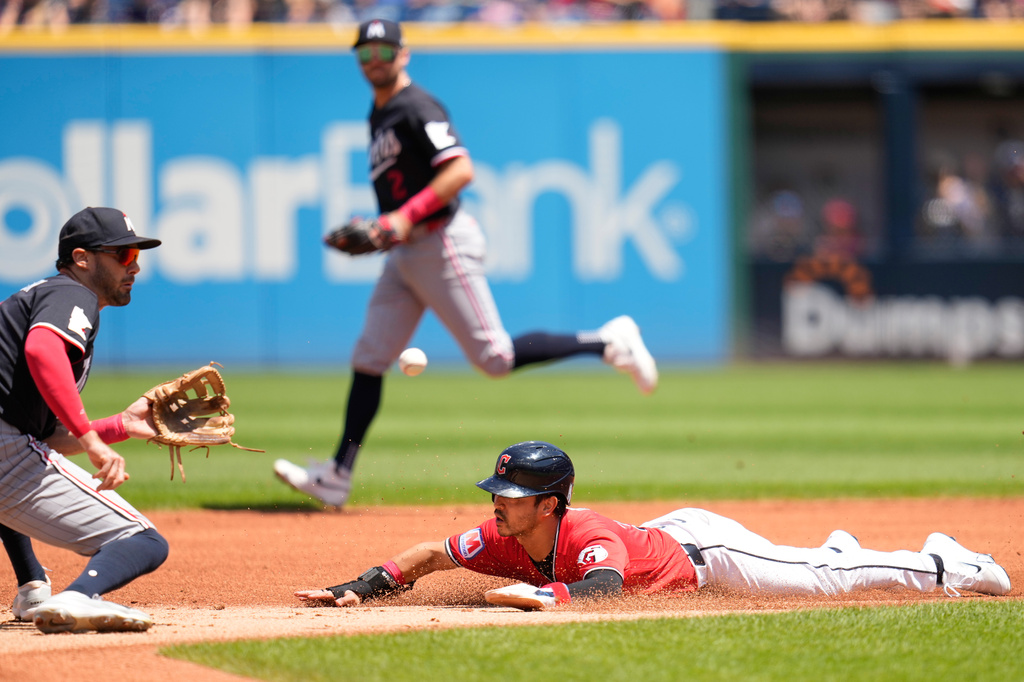 Cleveland Guardians' Steven Kwan, right, steals second base as Minnesota Twins shortstop Ryan Kreidler, left, takes the throw in the first inning of a baseball game in Cleveland, Thursday, July 23, 2026. (AP Photo/Sue Ogrocki)