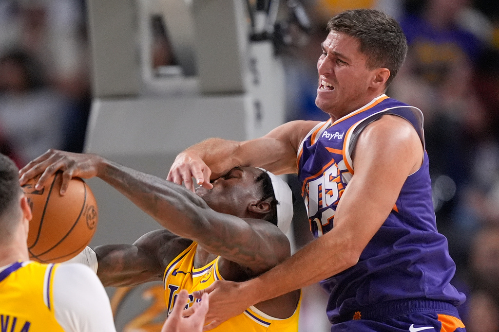 Los Angeles Lakers forward Jarred Vanderbilt, left, is hit in the face by Phoenix Suns guard Collin Gillespie as they go after a rebound during the first half of an NBA preseason basketball game Friday, Oct. 3, 2025, in Palm Desert, Calif. (AP Photo/Mark J. Terrill)