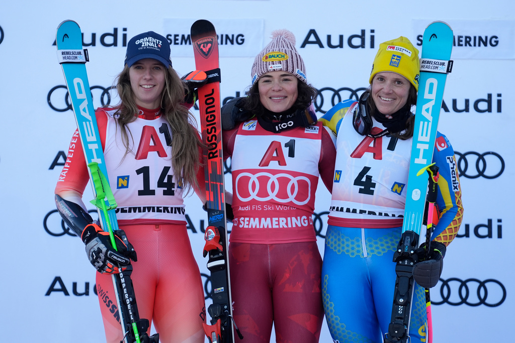Austria's Julia Scheib, center, winner of an alpine ski, women's World Cup giant slalom, poses with second-placed Switzerland's Camille Rast, left, and third-placed Sweden's Sara Hector, in Semmering, Austria, Saturday, Dec. 27, 2025. (AP Photo/Giovanni Auletta)
