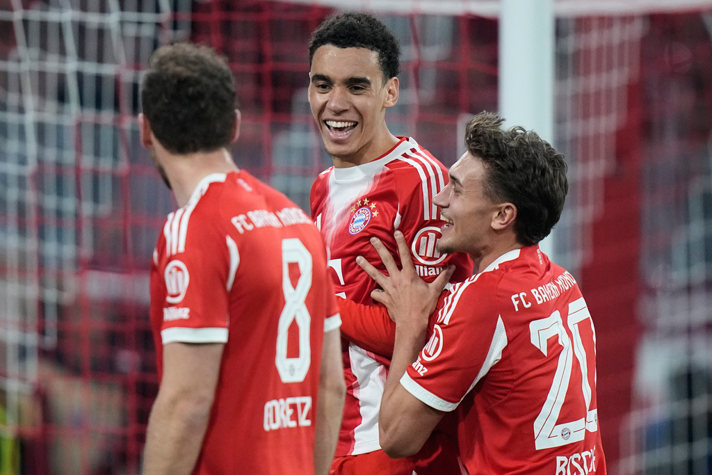 Bayern's Jamal Musiala, left, celebrates with team mate Tom Bischof after scoring from the penalty spot his side's third goal during the Bundesliga soccer match between FC Bayern Munich and Borussia Moenchengladbach in Munich, Germany, March 6, 2026. (AP Photo/Matthias Schrader)