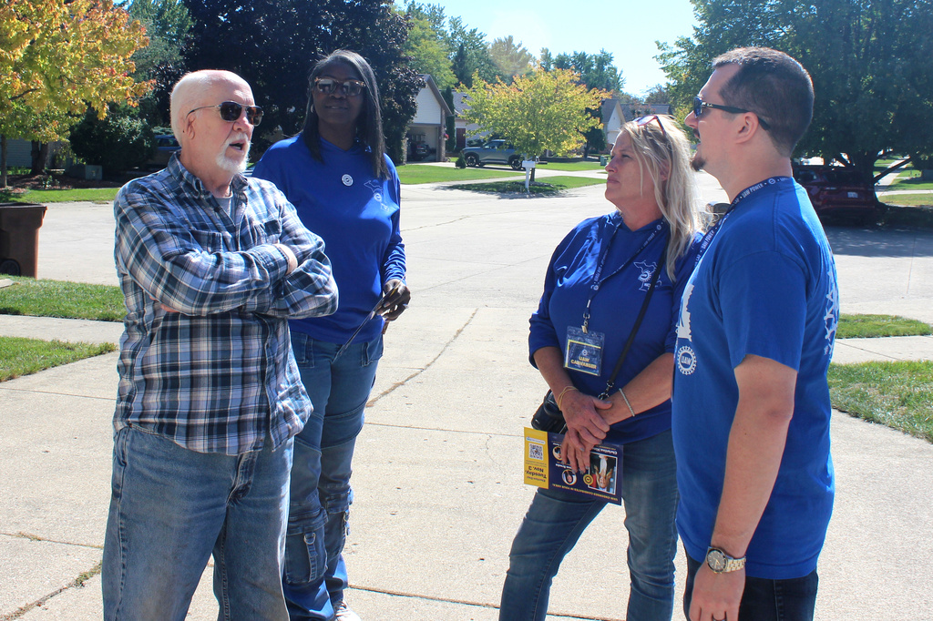 Walter Usakowski, from left, a retired worker from the Ford Motor Co.'s Sterling Axe Plant who plans to vote for the union's slate of Democratic candidates in the midterms, talks with United Auto Workers union canvassers LaShawn Barnett, Kim Avouris and JJ Jewell in Shelby Township, Mich., Saturday, Sept. 26, 2026. (AP Photo/Jacqueline GaNun)