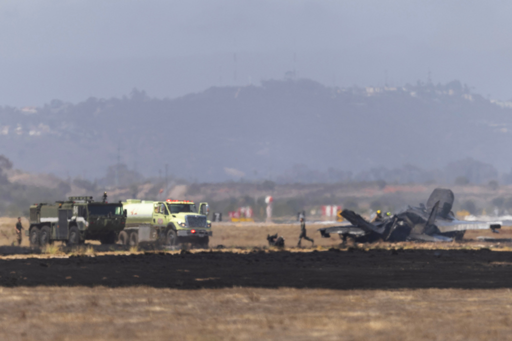 Crews work to douse a F-35 fighter jet that crashed near the run way at Marine Corps Air Station Miramar on Friday, July 31, 2026, in San Diego. (Luke Johnson/The San Diego Union-Tribune via AP)