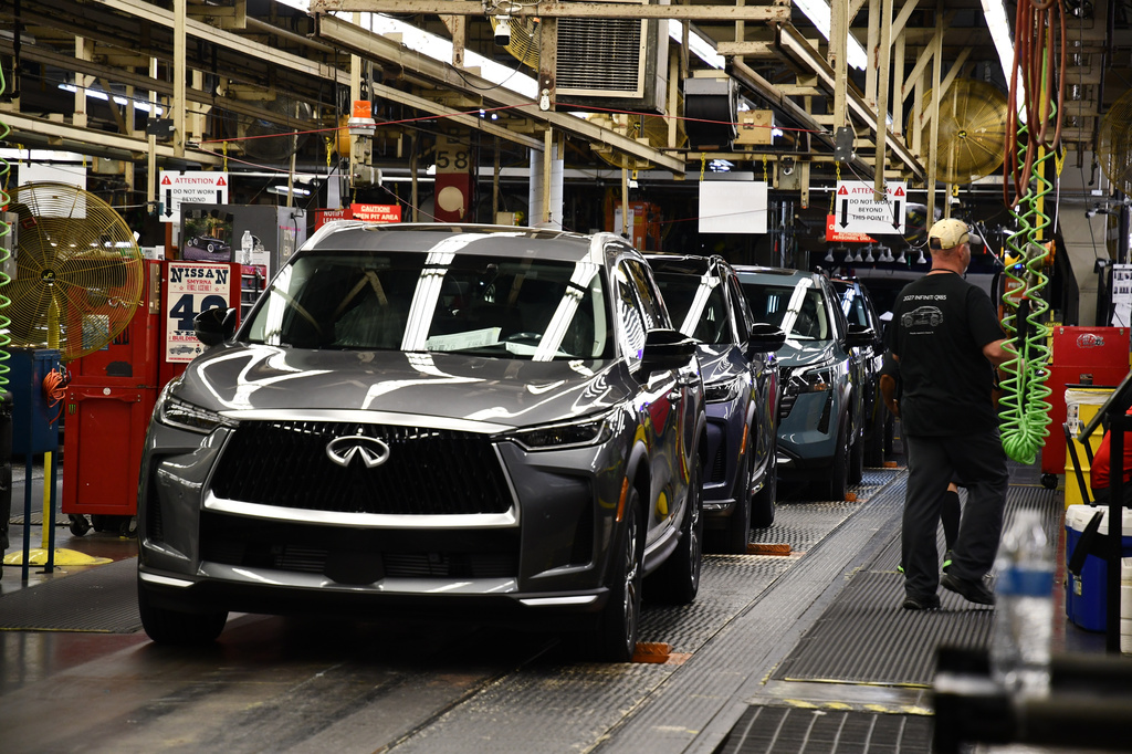 A worker walks past a line of Infiniti SUVs on a production line at the Nissan Smyrna Vehicle Assembly Plant, Thursday, April 16, 2026, in Smyrna, Tenn. (AP Photo/Kristin M. Hall)