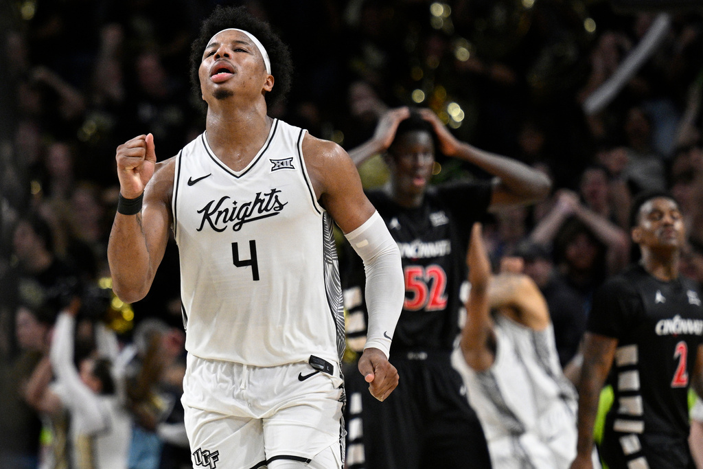 Central Florida forward Jamichael Stillwell (4) celebrates after getting the win as Cincinnati center Moustapha Thiam (52) and guard Jizzle James (2) look on during the second half of an NCAA college basketball game, Sunday, Jan. 11, 2026, in Orlando, Fla. (AP Photo/Phelan M. Ebenhack)