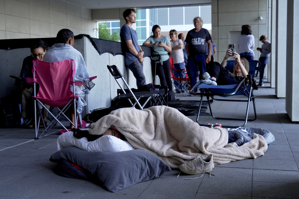 A woman sleeps outside the courthouse in hopes to get access to the limited public seating available at a preliminary hearing for Tyler Robinson, the Utah man accused of fatally shooting Charlie Kirk, in Provo, Utah, Thursday, July 9, 2026. (AP Photo/Ty ONeil)
