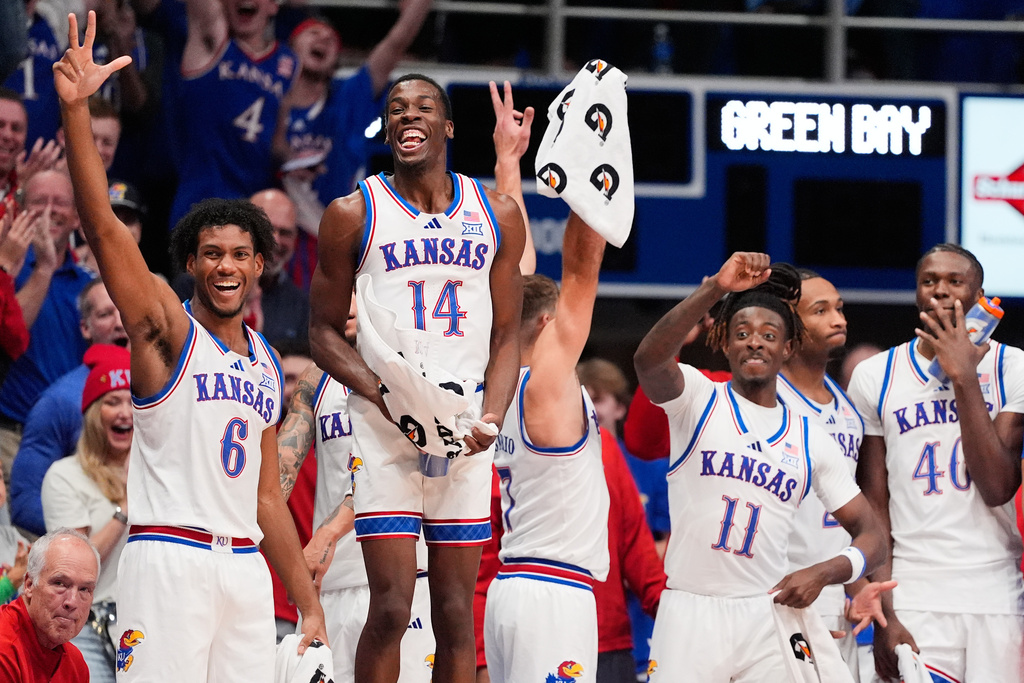 Kansas players on the bench celebrate a teammate's basket during the second half of an NCAA college basketball game against Green Bay, Monday, Nov. 3, 2025, in Lawrence, Kan. (AP Photo/Charlie Riedel)