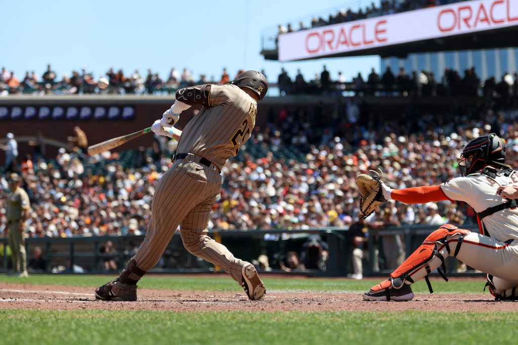 San Diego Padres' Ty France (25) hits a two-run triple in front of San Francisco Giants catcher Patrick Bailey, right, during the seventh inning of a baseball game in San Francisco, Wednesday, May 6, 2026. (AP Photo/Jed Jacobsohn)