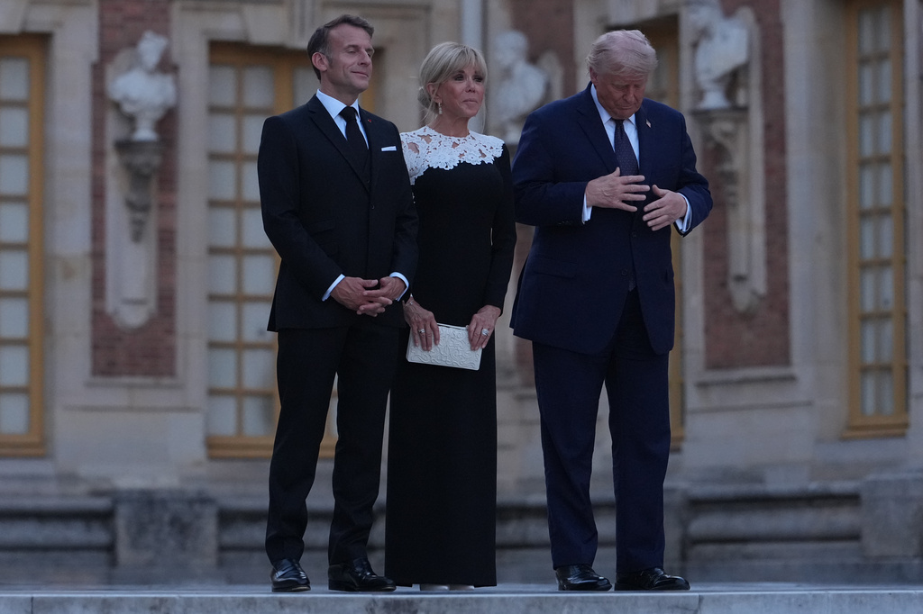 U.S. President Donald Trump is greeted by French President Emmanuel Macron and first lady Brigitte Macron as he arrives at the Palace of Versailles, Wednesday, June 17, 2026, in Versailles, France. (AP Photo/Julia Demaree Nikhinson)