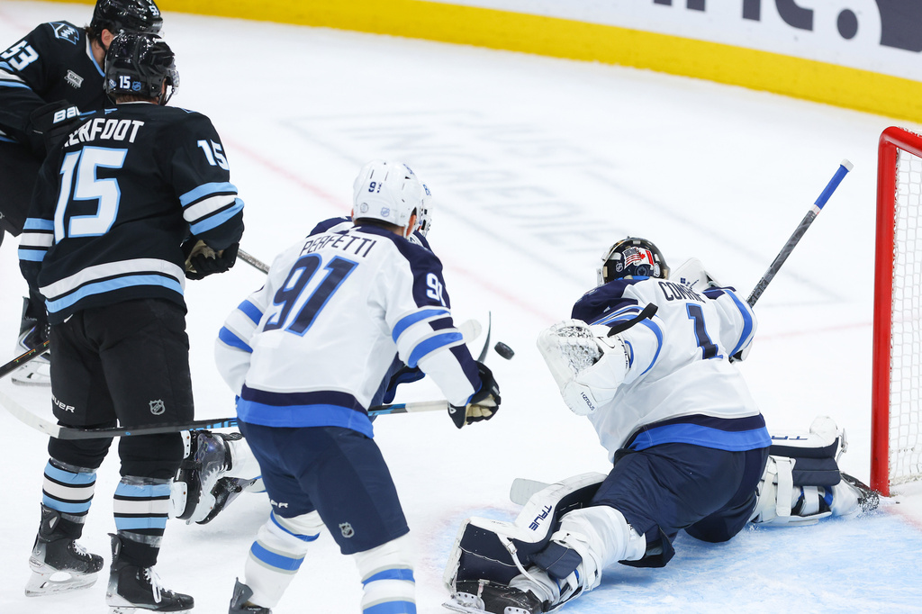 Winnipeg Jets goalie Eric Comrie (1) blocks the shot against Utah Mammoth left wing Michael Carcone (53) during the second period of an NHL hockey game, Tuesday, April 14, 2026, in Salt Lake City. (AP Photo/Melissa Majchrzak)