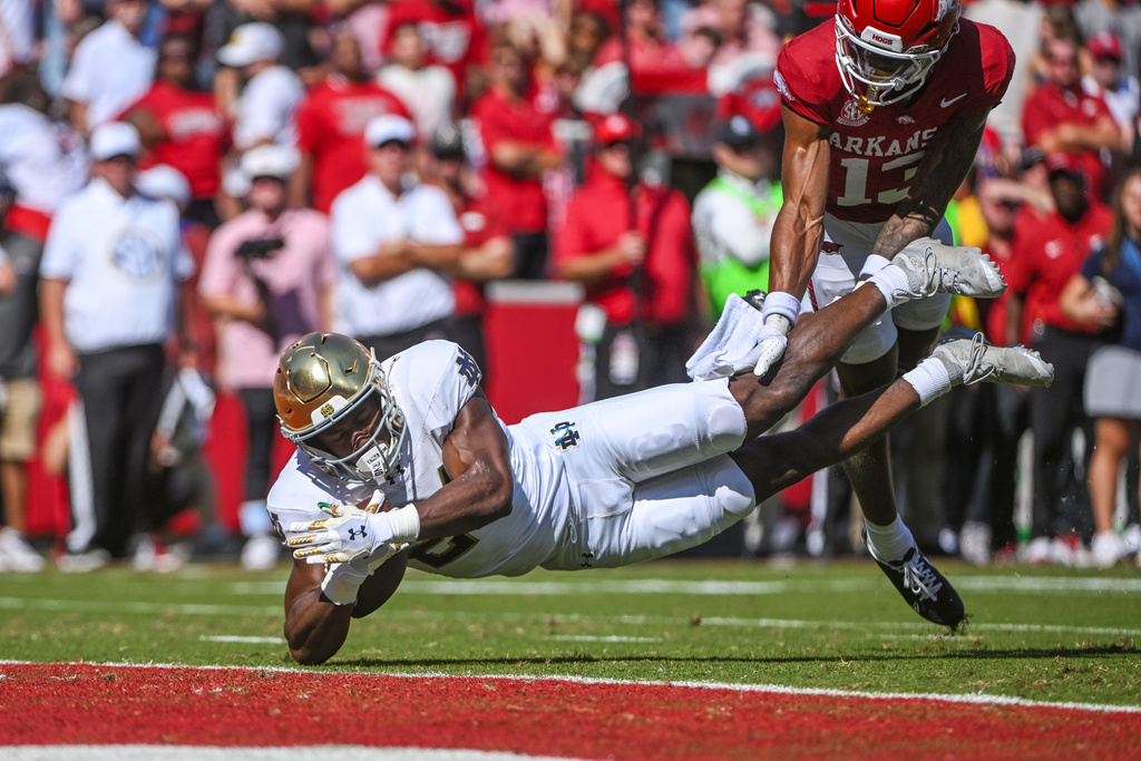 Notre Dame running back Jadarian Price (24) dives to the one-yard line in front af Arkansas defensive back Kani Walker (13) during an NCAA college football game Saturday, Sept. 27, 2025, in Fayetteville, Ark. (AP Photo/Michael Woods)