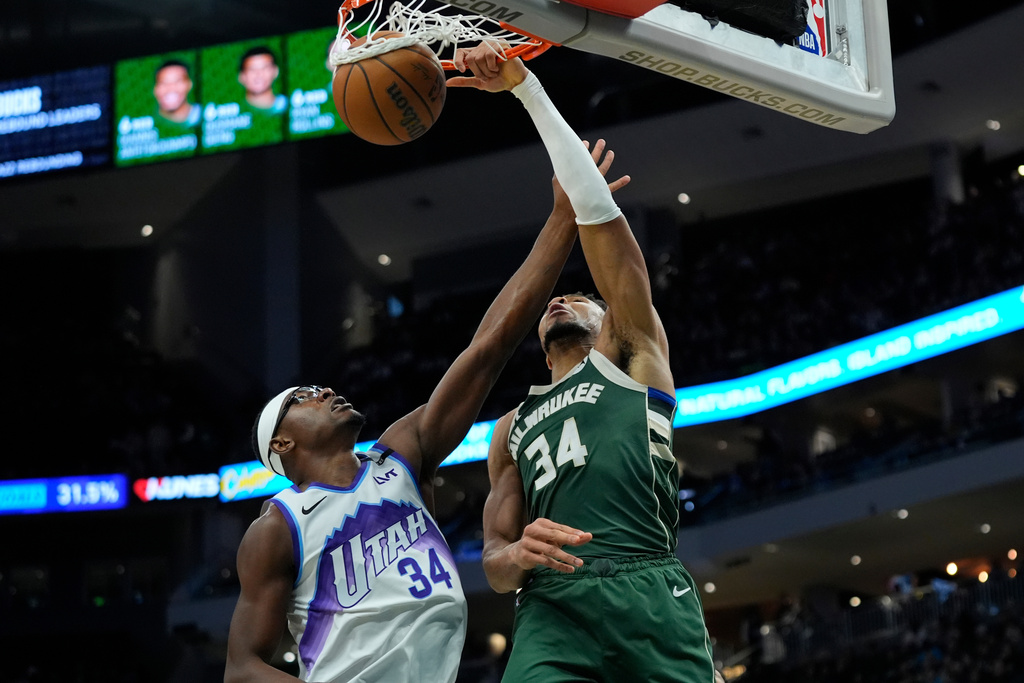 Milwaukee Bucks' Giannis Antetokounmpo, right, dunks over Utah Jazz's Oscar Tshiebwe, left, during the second half of an NBA basketball game Saturday, March 7, 2026, in Milwaukee. (AP Photo/Aaron Gash)