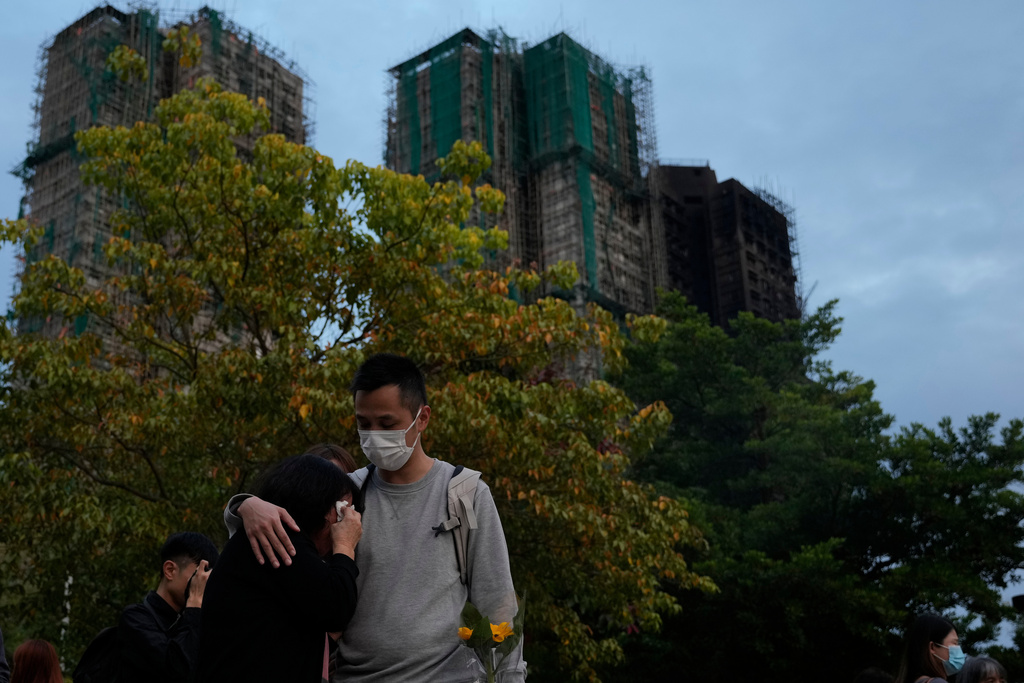 A man consoles a woman at the site of last weeks deadly fire at Wang Fuk Court, a residential estate in the Tai Po district of Hong Kong's New Territories on Tuesday, Dec. 2, 2025. (AP Photo/Ng Han Guan)