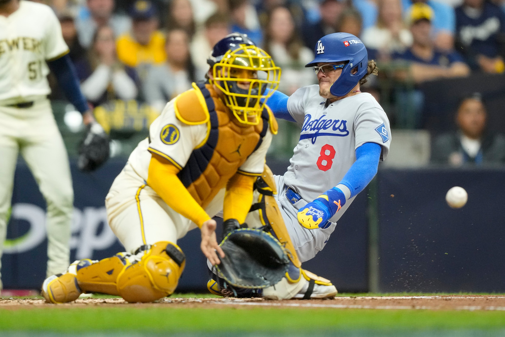 Los Angeles Dodgers' Enrique Hernández scores past Milwaukee Brewers catcher William Contreras on a double by Andy Pages during the second inning in Game 2 of baseball's National League Championship Series, Tuesday, Oct. 14, 2025, in Milwaukee. (AP Photo/Brynn Anderson)