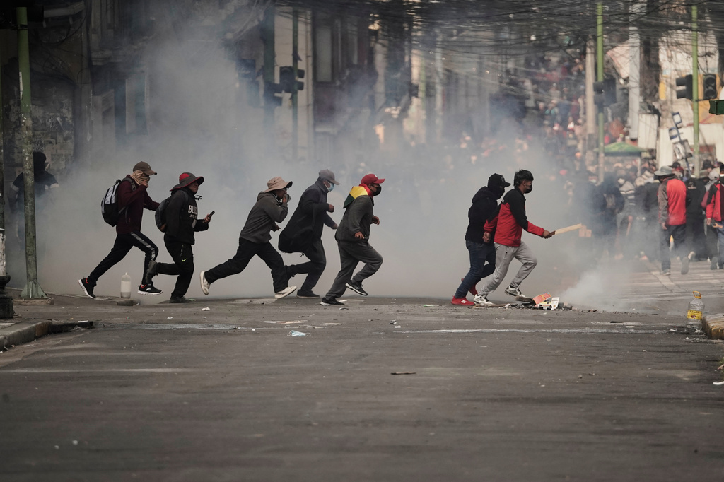 Demonstrators run across a street during an anti-government protest in La Paz, Bolivia, Monday, May 18, 2026. (AP Photo/Freddy Barragan)