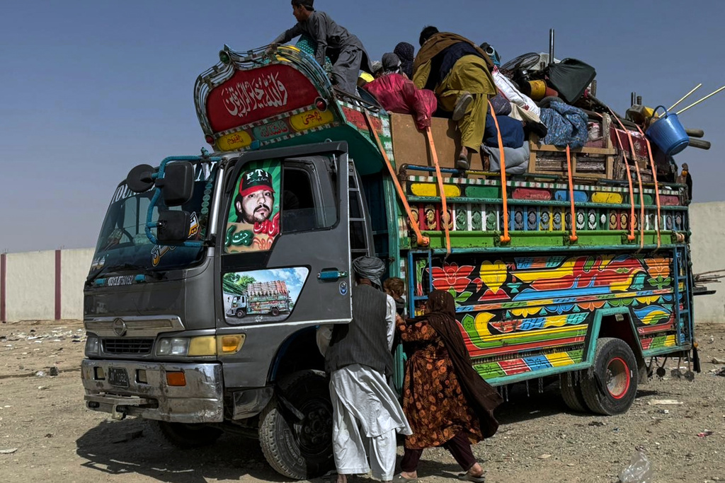 Afghan refugees board into a truck as they prepare to leave for their homeland through a border crossing point which partially opens following Pakistan Afghanistan ceasefire truce, at a camp in Chaman, a border town on the Pakistan Afghan border, Sunday, Oct. 19, 2025. (AP Photo/H. Achakzai)