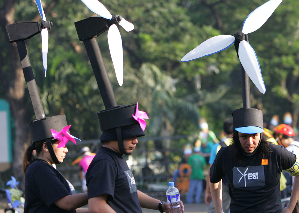 FILE -Participants wear wind turbine headgear to raise peoples awareness on renewable energy, fix their costumes during the Global Day of Action Against Climate Change ,Dec. 8, 2007 in suburban Quezon City, north of Manila, Philippines. (AP Photo/Pat Roque, File)