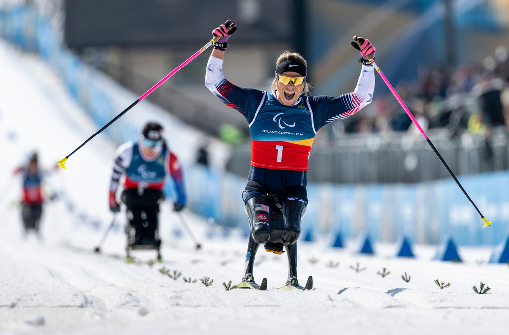 Oksana Masters of the US celebrates as she crosses the finish line to win the Para Cross Country Skiing Women's Sprint Sitting Final competition at the 2026 Winter Paralympics, in Tesero, Italy, Tuesday March 10, 2026. (Shana Abitbol/OIS/IOC via AP)