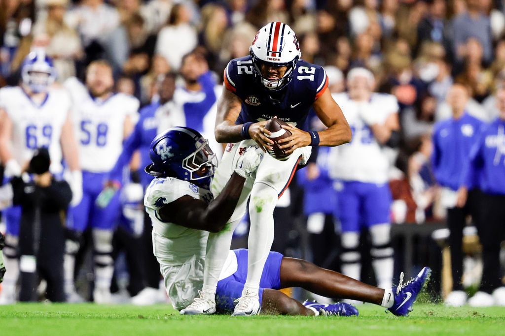 Auburn quarterback Ashton Daniels (12) is sacked by Kentucky defensive lineman Kahlil Saunders (92) during the second half of an NCAA college football game, Saturday, Nov. 1, 2025, in Auburn, Ala. (AP Photo/Butch Dill)
