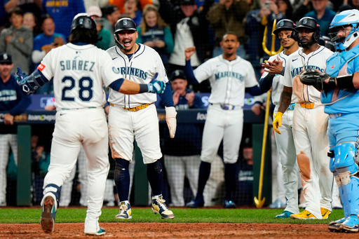 Seattle Mariners' Eugenio Suárez (28) comes in to celebrate with teammates after hitting a grand slam during the eighth inning of Game 5 of baseball's American League Championship Series against the Toronto Blue Jays in Seattle, Friday, Oct. 17, 2025. (Frank Gunn/The Canadian Press via AP) Seattle Mariners' Eugenio Suárez (28) comes in to celebrate with teammates after hitting a grand slam during the eighth inning of Game 5 of baseball's American League Championship Series against the Toronto Blue Jays in Seattle, Friday, Oct. 17, 2025. (Frank Gunn/The Canadian Press via AP)
