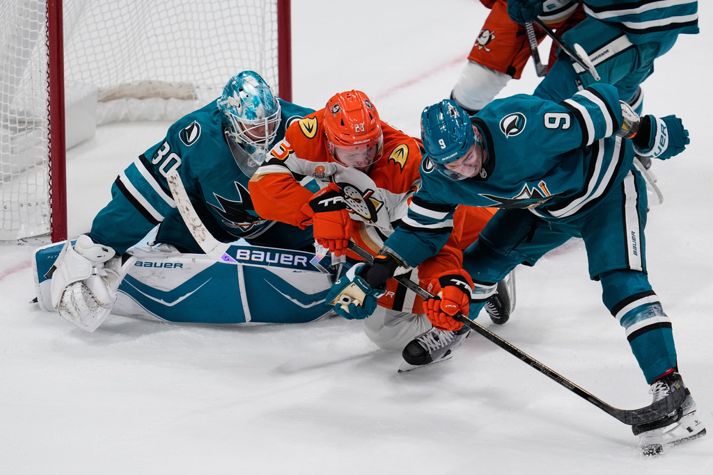 Anaheim Ducks center Mason McTavish (23) and San Jose Sharks defenseman Dmitry Orlov (9) compete for possession of the puck during the third period of an NHL hockey game, Saturday, Oct. 11, 2025, in San Jose, Calif. (AP Photo/Godofredo A. Vásquez)