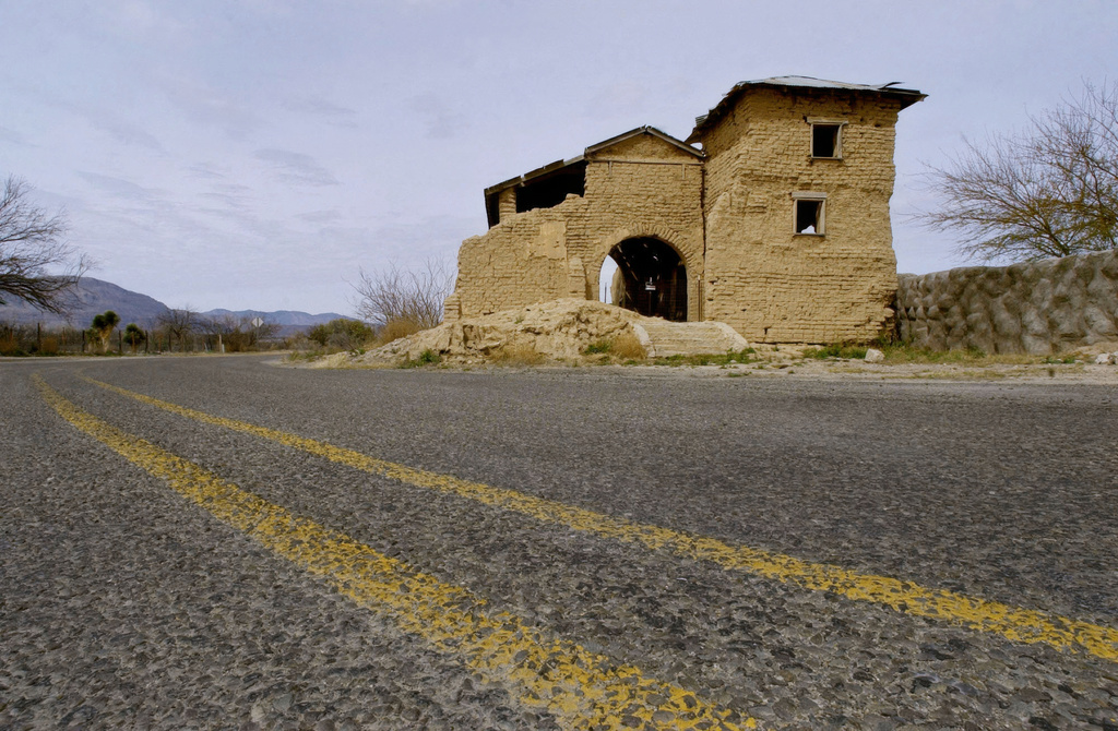 FILE - Texas State Highway 170 passes The Mission del Sagrado Corazon in Ruidosa, Texas, Feb. 9, 2005. The church once had a second tower on the front left like that one on the right. The pile of mud debris from the collapsed tower can still be seen on the front left. (AP Photo/Tony Gutierrez)