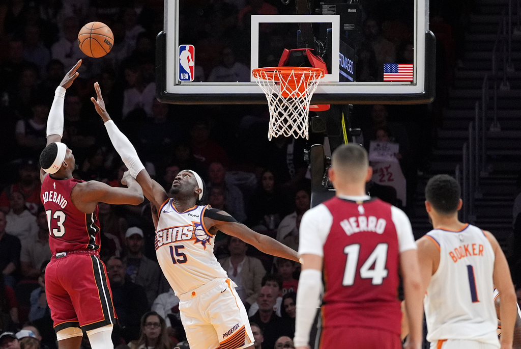 Miami Heat center/forward Bam Adebayo (13) shoots over Phoenix Suns center Mark Williams (15) during the first half of an NBA basketball game, Tuesday, Jan. 13, 2026, in Miami. (AP Photo/Rebecca Blackwell)