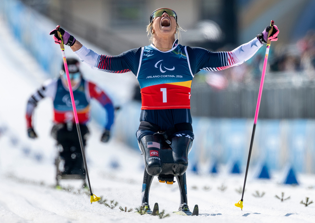 Oksana Masters of the US celebrates as she crosses the finish line to win the Para Cross Country Skiing Women's Sprint Sitting Final competition at the 2026 Winter Paralympics, in Tesero, Italy, Tuesday March 10, 2026. (Shana Abitbol/OIS/IOC via AP)