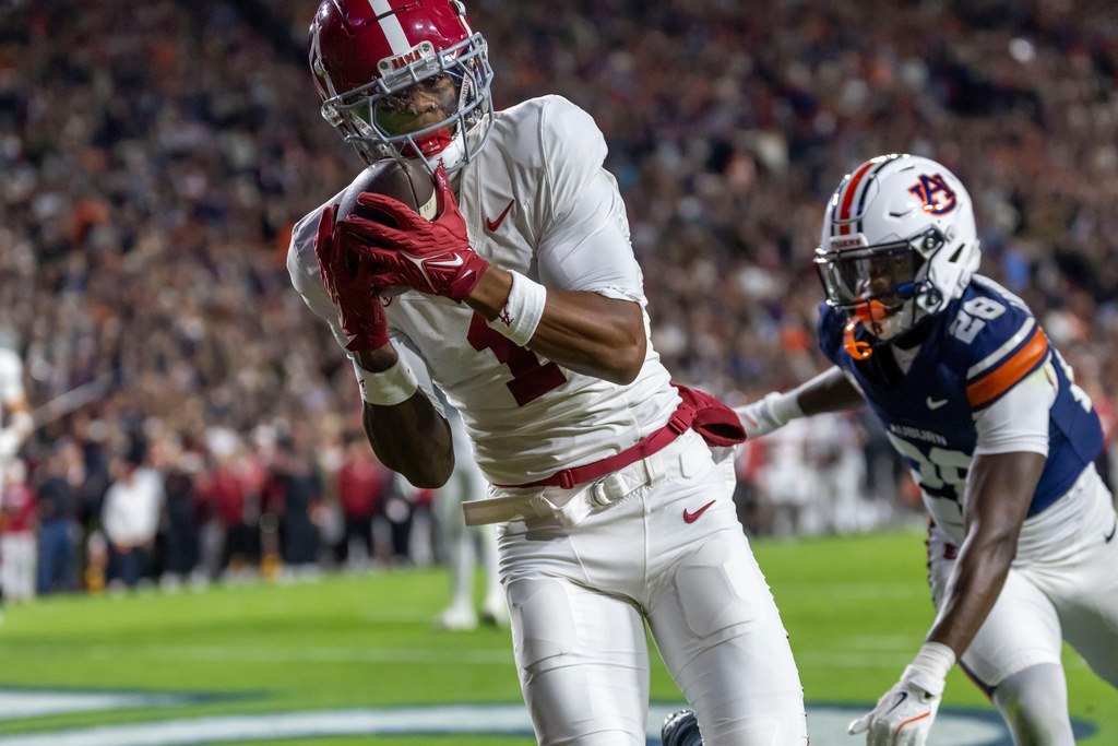 Alabama wide receiver Isaiah Horton, left, grabs a touchdown pass in front of Auburn defensive back Kensley Louidor-Faustin (28) during the first half of an NCAA college football game, Saturday, Nov. 29, 2025, in Auburn, Ala. (AP Photo/Vasha Hunt)