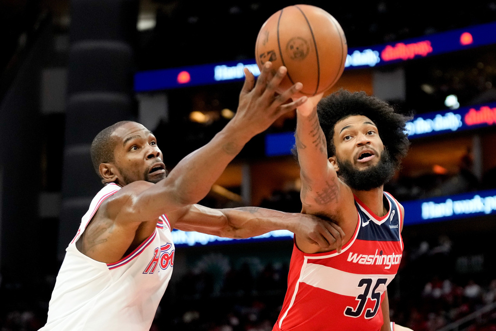 Washington Wizards forward Marvin Bagley III (35) and Houston Rockets forward Kevin Durant reach for a loose ball during the first half of an NBA basketball game, Wednesday, Nov. 12, 2025, in Houston. (AP Photo/Eric Christian Smith)