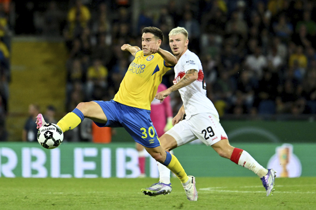 Eintracht Braunschweig's Robin Heusser, left, reaches for the ball ahead of VfB Stuttgart's Finn Jeltsch during a DFB Pokal, German Cup, soccer match, Tuesday, Aug. 26, 2205, in Brunswick, Germany. (Swen Pförtner/dpa via AP)