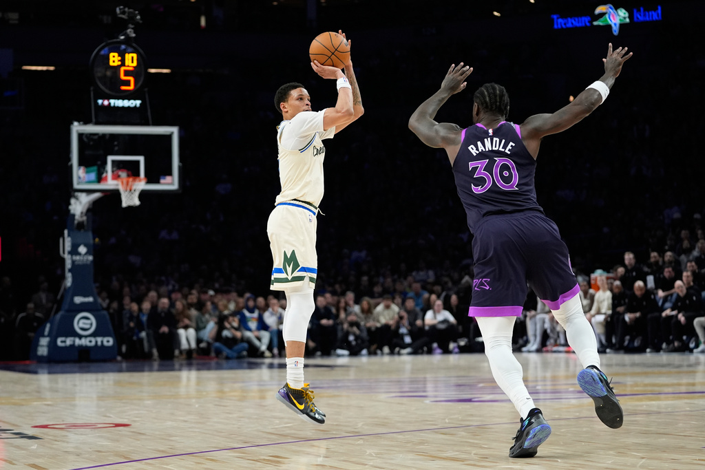 Milwaukee Bucks guard Ryan Rollins shoots over Minnesota Timberwolves forward Julius Randle (30) during the second half of an NBA basketball game, Sunday, Dec. 21, 2025, in Minneapolis. (AP Photo/Abbie Parr)
