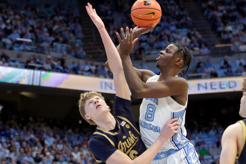 North Carolina forward Caleb Wilson (8) shoots against Notre Dame forward Brady Koehler (6) during the first half of an NCAA college basketball game Wednesday, Jan. 21, 2026, in Chapel Hill, N.C. (AP Photo/Chris Seward)