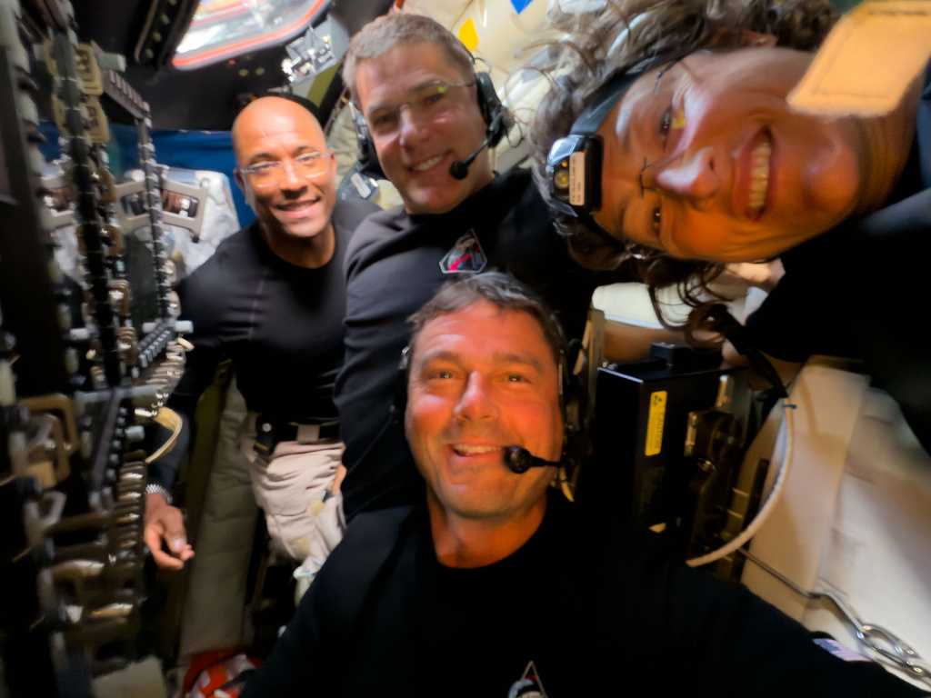 In this image provided by NASA, Artemis II crew members, from left, Victor Glover, Jeremy Hansen, Reid Wiseman and Christina Koch, pause to turn the camera around for a selfie midway through their lunar observation period of the Moon during a lunar flyby, Monday, April 6, 2026. (NASA via AP)